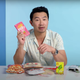 Simu Liu holding up package of Pocky